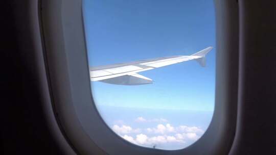飞机舷窗视角中的蓝天白云