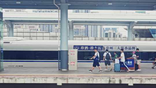 高铁列车驶过站台旅客上车