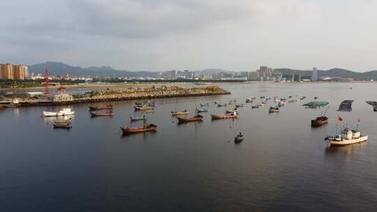 航拍沿海城市海上渔船日落场景