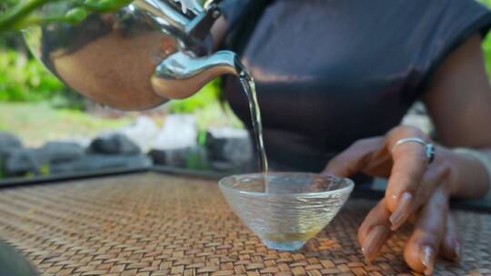 慢镜头倒茶水视频手部茶水杯特写