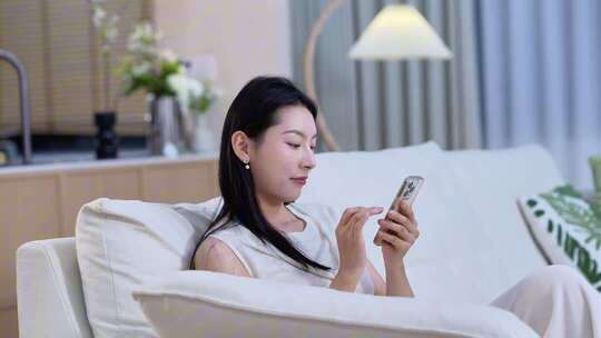 女子居家沙发上玩手机