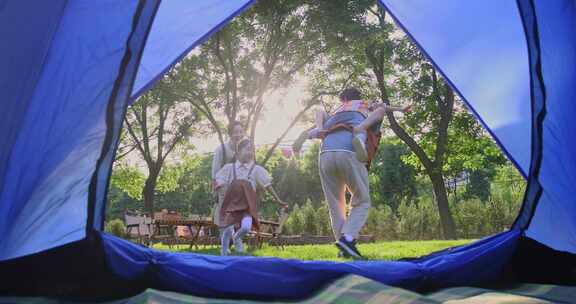 透过帐篷一家四口在露营地开心玩耍