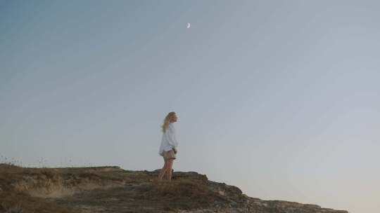 女孩孤独的站在山头，头顶一顶月牙视频素材模板下载