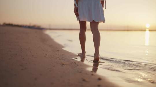 夕阳下少女走在沙滩上，海浪不停冲来