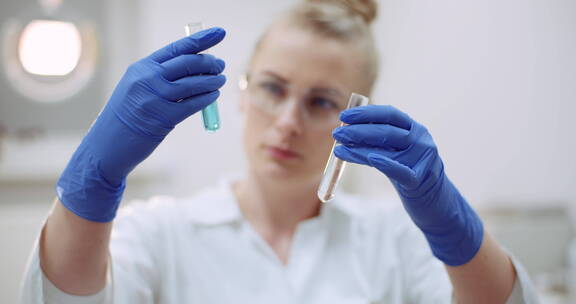 女科学家观察手里的两支试管溶剂