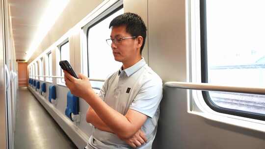 男子在卧铺火车过道上使用手机