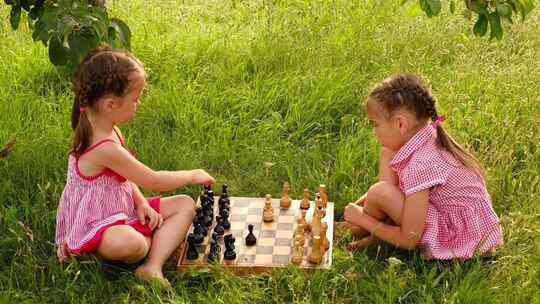 姐妹在草地上下国际象棋
