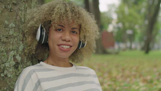 公园里戴着耳机的快乐女孩肖像