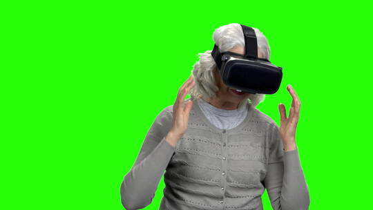 绿幕上老年妇女戴虚拟现实眼镜