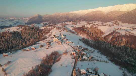 日出在白雪覆盖的屋顶的佩斯特拉村，空中冬