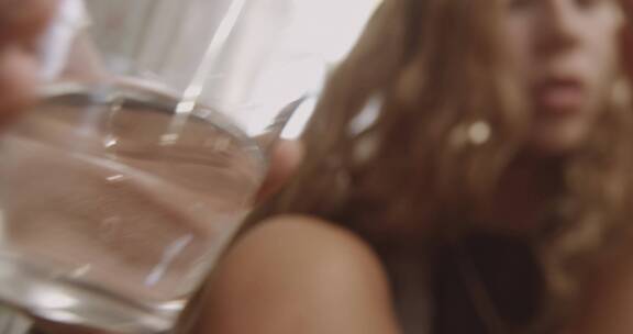 女孩端起水杯喝水吃药片