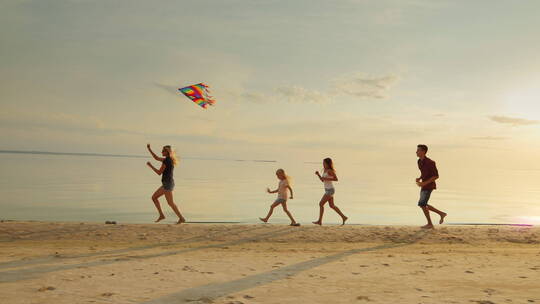 一群孩子和大人一起在海滩上奔跑