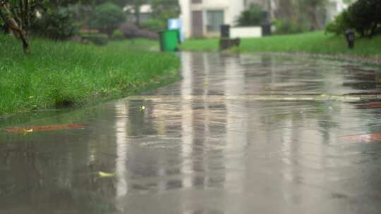 雨后小区地面特写，湿滑路面反射周围景色