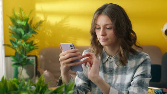 漂亮年轻女子专注于在家浏览手机的中景