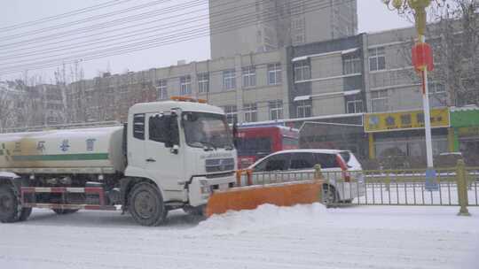 4k北方城市下大雪的马路上的除雪车除雪