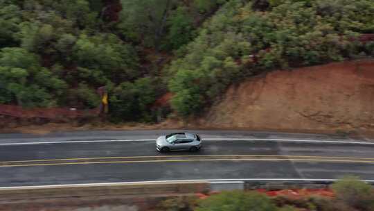 航拍新能源汽车行驶在山区公路上