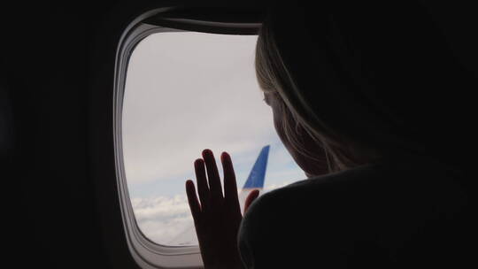 女人从飞机窗户往外看风景