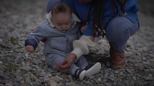 母亲抱着年幼的男婴在外面享受家庭生活