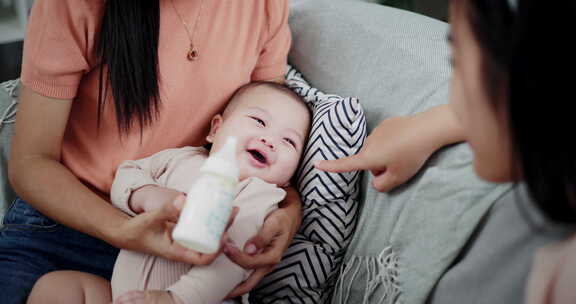 两个女人在家里客厅的沙发上开心地和一个小