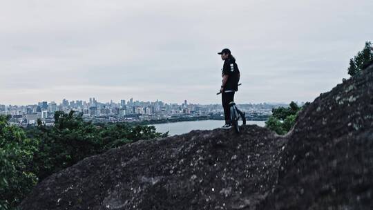 小轮车手在宝石山上俯瞰杭州城市