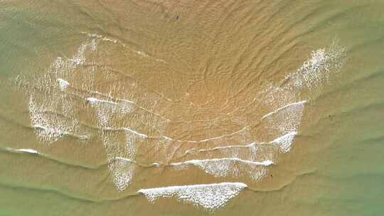 航拍俯瞰山东威海国际海水浴场沙滩上的海浪视频素材模板下载