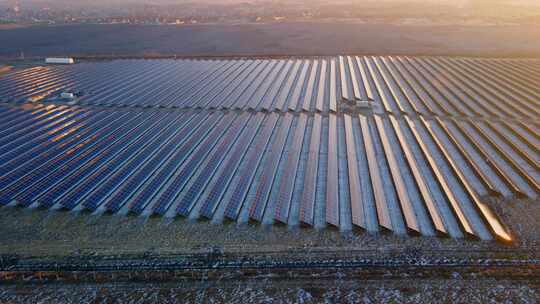 初冬明亮日落时太阳能农场大型太阳能电池板的无人机视图视频素材模板下载