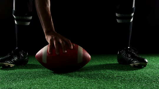 橄榄球运动员弯着腰握着橄榄球视频素材模板下载