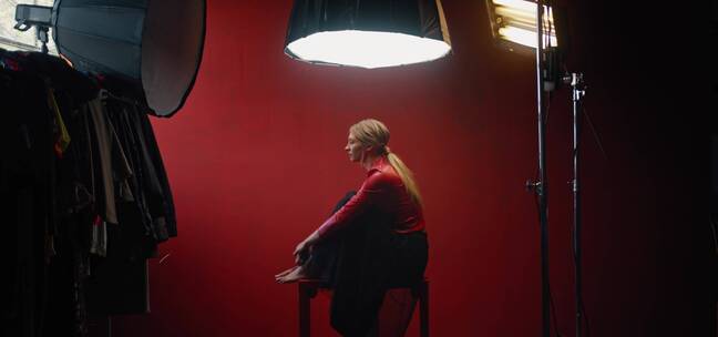 红衣女模特坐在聚光灯下拍摄