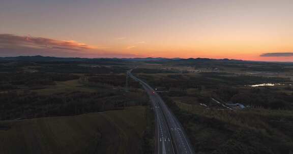 航拍夕阳下穿过草原的高速公路