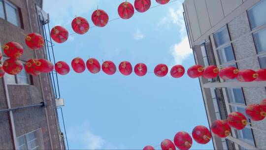 抬头看着悬挂在伦敦唐人街的红色中国灯笼视频素材模板下载