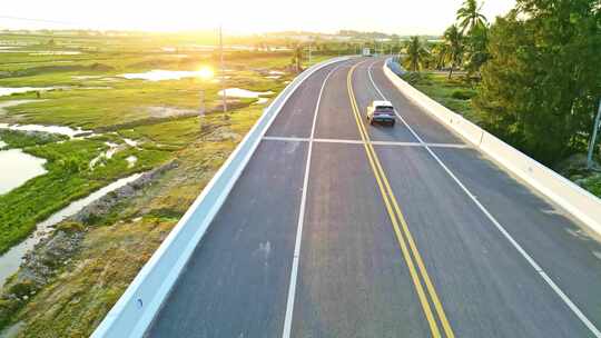 海南陵水环岛旅游公路阳光下的新能源汽车