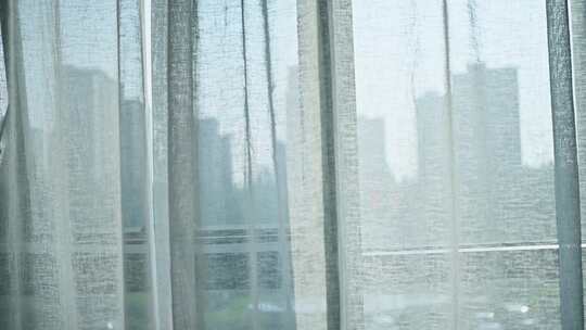 透过窗帘看城市高楼景观