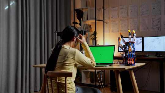 在模拟绿屏笔记本电脑上设计电子人手时头痛的少女