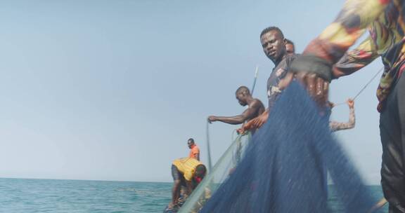 渔民们在渔船上拉渔网