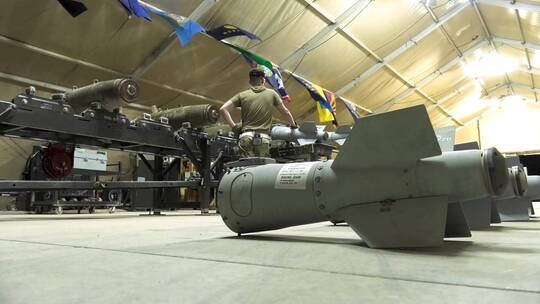 空军的弹药商店的飞行员为轰炸任务组装武器和弹药