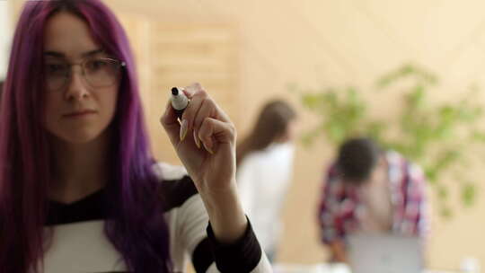 紫色头发的女人用记号笔在玻璃上的写字视频素材模板下载