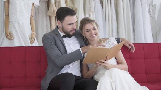 新郎新娘在试衣间沙发上选礼服视频素材模板下载