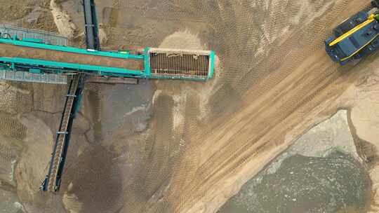 航拍挖掘机将砂石倒入传送带视频素材模板下载