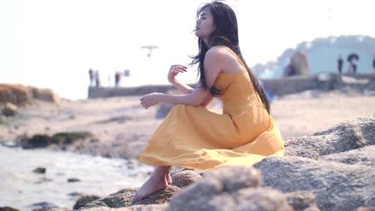 长裙女孩坐海边吹风思考，唯美文艺视频素材