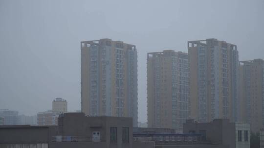 阴天雨雾下雨中的城市楼房视频素材模板下载