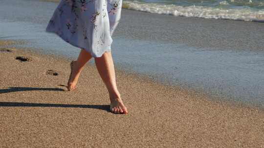 少女光脚走在沙滩上，蓝色裙子