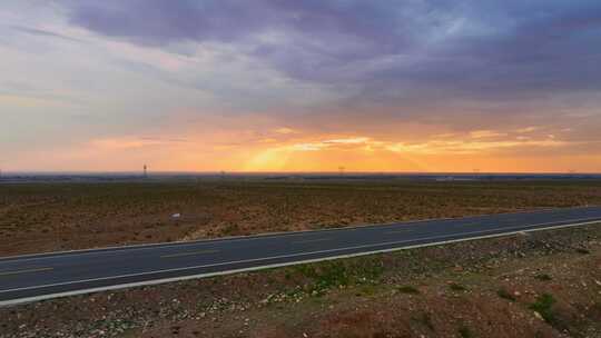 航拍夕阳下的戈壁公路车辆行驶