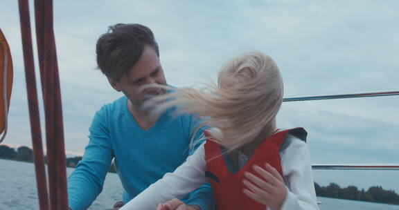 爸爸和女儿坐在帆船上