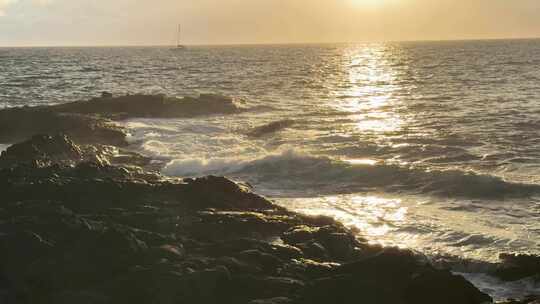 夏威夷大岛上的日落，海浪卷进岩石海岸。