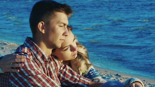 浪漫的夫妇在海滩上放松，她紧紧抓住那个家伙