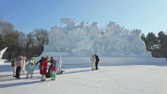 群马八骏图雪雕群像前的游客冰雪雕塑哈尔滨