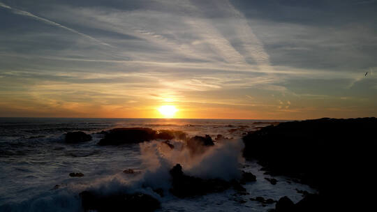 海上日出海鸥飞翔海边海浪拍打岩石