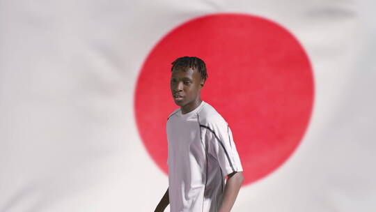 足球运动员在日本国旗前欢呼跳跃