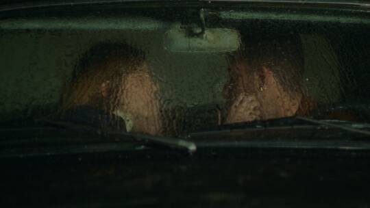 下雨天情侣坐在汽车里互相抚摸脸颊