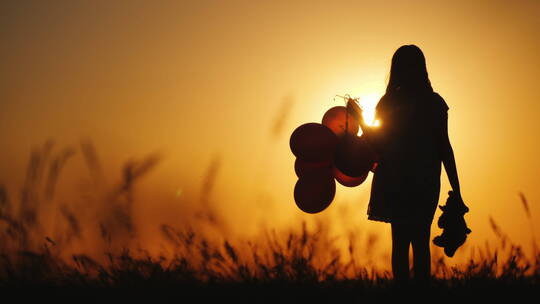 日落下女孩拿着气球和泰迪熊的剪影视频素材模板下载